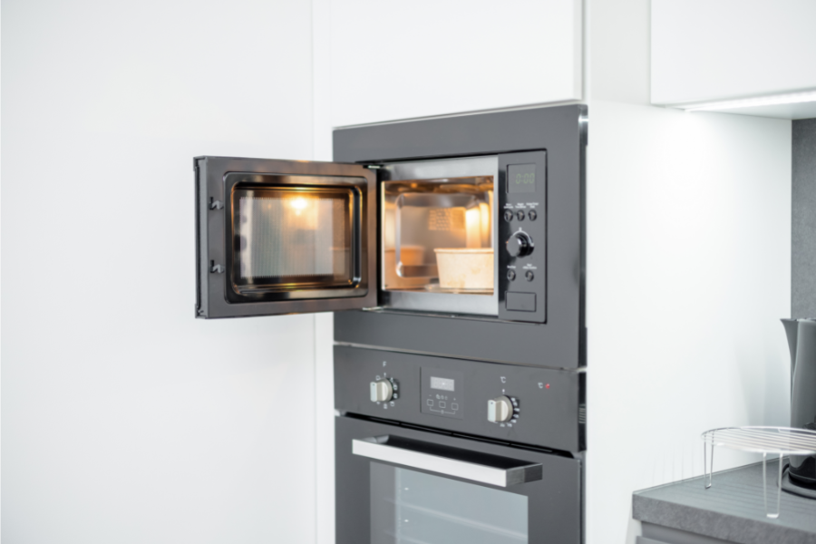 a microwave built into a kitchen cupboard above an oven