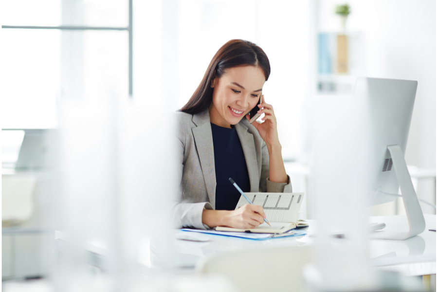 a woman real estate agent on a phone at a desk