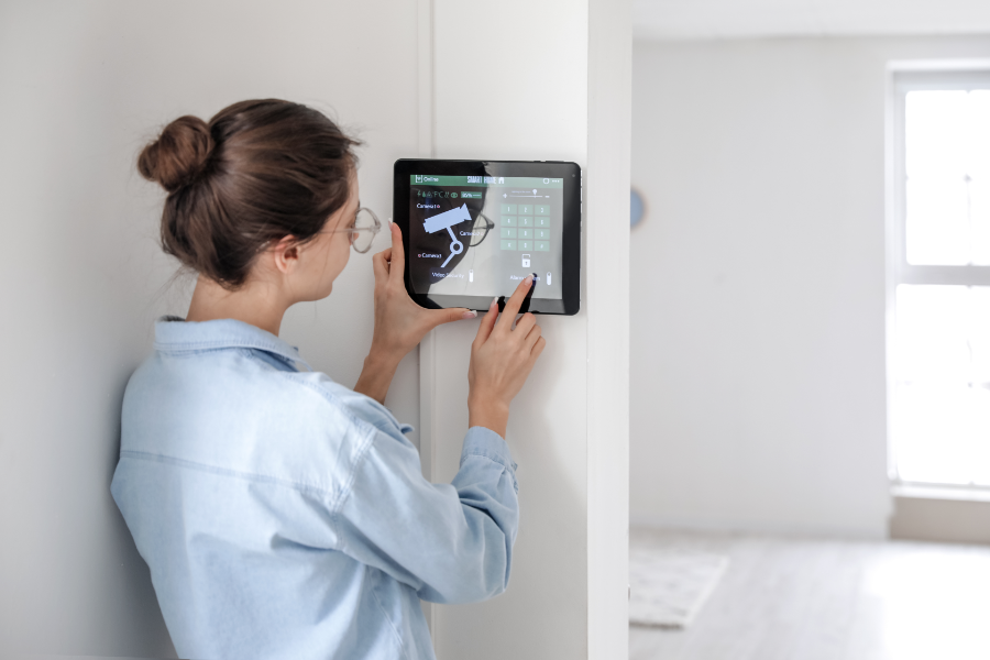 a woman controlling a home security camera system on a wall